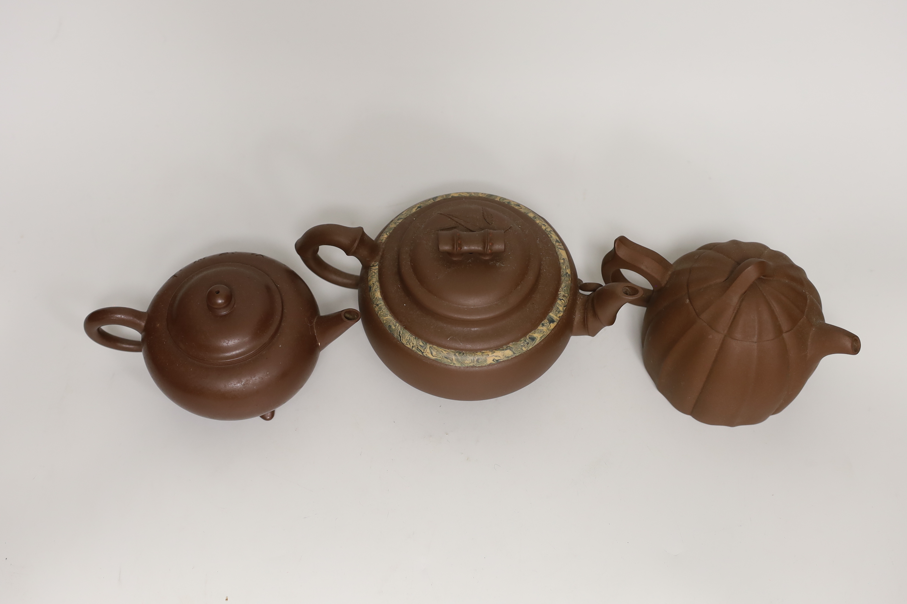 Three Chinese Yixing dark brown zisha clay teapots, one with marbled clay band largest 12cm diam.